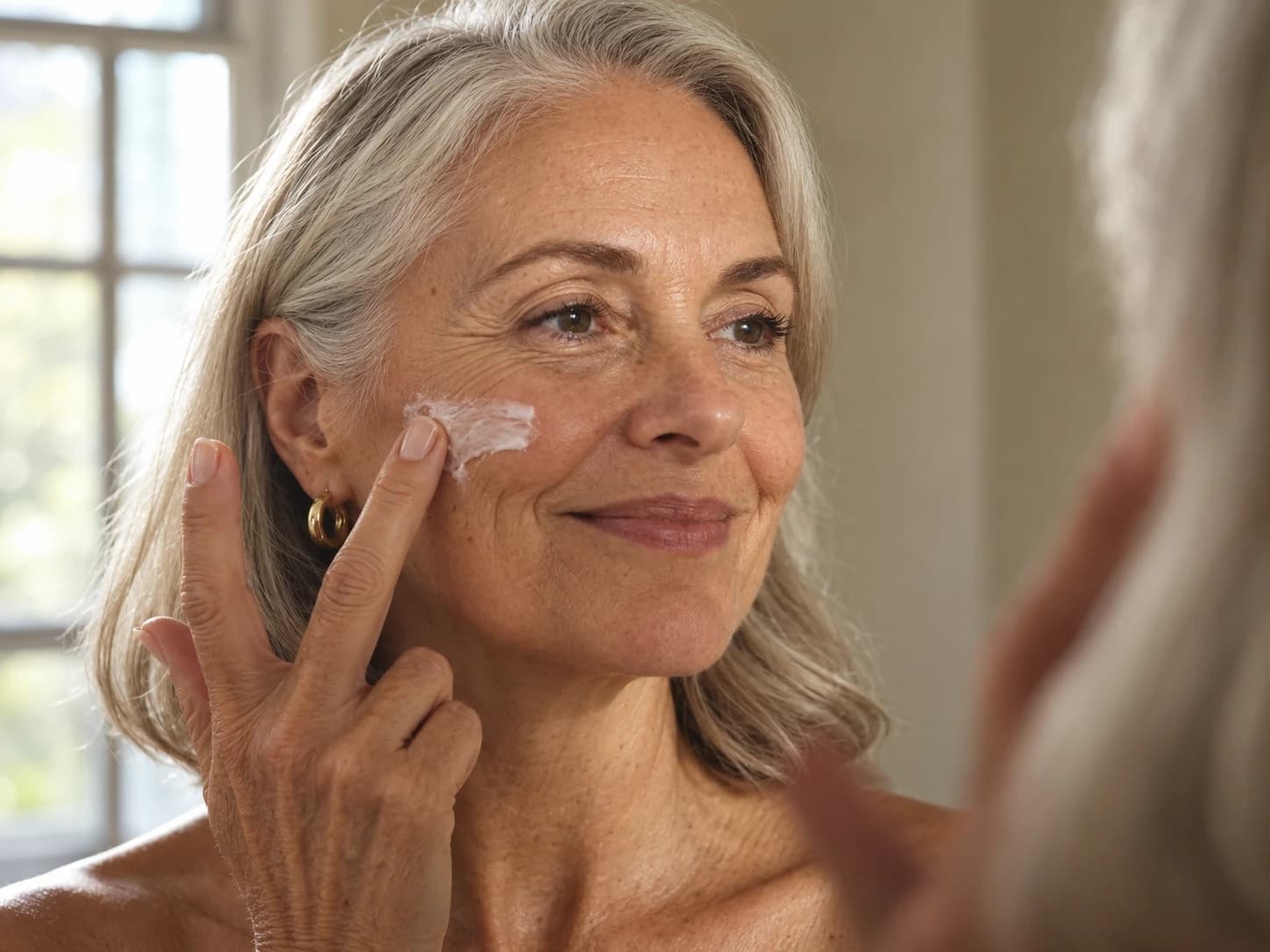 A woman checking her skin in a bathroom mirror
